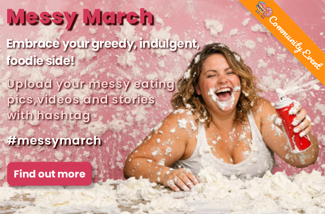 Plus size woman holding a can of whipped cream that is being sprayed into her mouth, the whipped cream has got mesy and sprayed everywhere all over her face, the background and table. This is a promotional image for the community event - Messy March - where members can upload pics, videos and stories based on the messy eating theme.